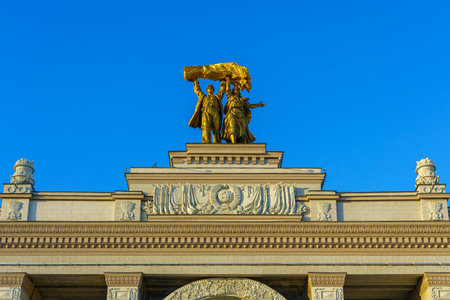 Moscow; Russia - December 24; 2024 - The arch of the main entrance to VDNH on a blue sky background on sunset.の写真素材