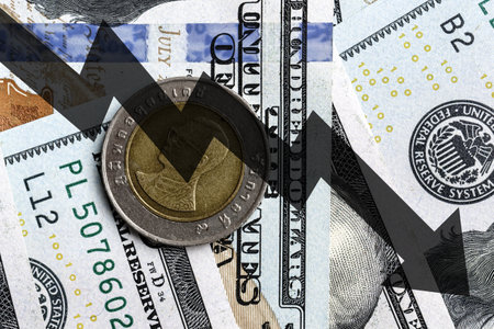 Close-up of a Thai Baht coin placed on US 100 dollar bills and arrow down. Concept of currency falling.の写真素材