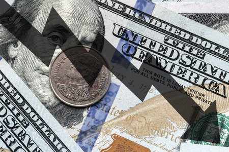 Close-up of a Thai Baht coin placed on US 100 dollar bills and arrow down. Concept of currency falling.の写真素材