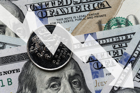 Close-up of a Czech crown coin placed on US 100 dollar bills and arrow down. Concept of currency decrease.の写真素材