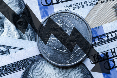 Close-up of a Russian ruble coin placed on US 100 dollar bills and arrow down. Concept of currency falling.の写真素材