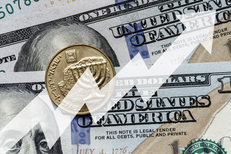 Close-up of a Israel shekel coin placed on US 100 dollar bills and arrow up. Concept of currency increase.の写真素材