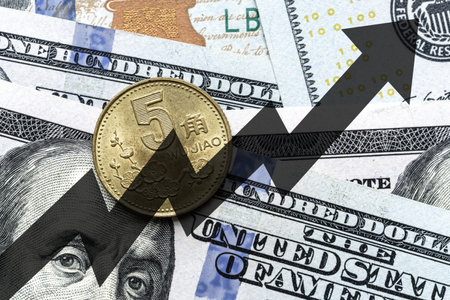 Close-up of a 5 Chinese wujiao coin placed on US 100 dollar bills and arrow up. Concept of currency increasing.の写真素材