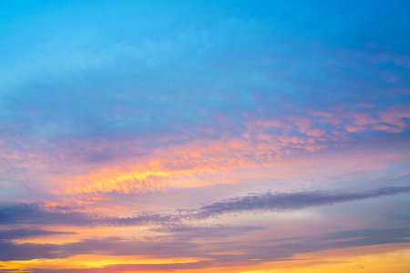 A beautiful sunset or sunrise sky with vibrant clouds changing from purple to orange is perfect for an abstract or nature background.の写真素材