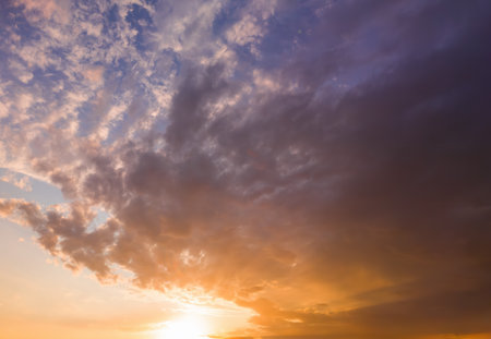 Sunset or sunrise sky with dramatic, colorful clouds. Beautiful natural background for concepts of weather, climate, and nature.の写真素材