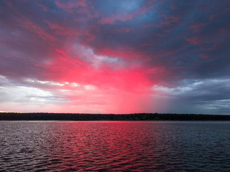 Red sky over a lake at dusk, creating a beautiful sunset or sunrise landscape for nature and travel...