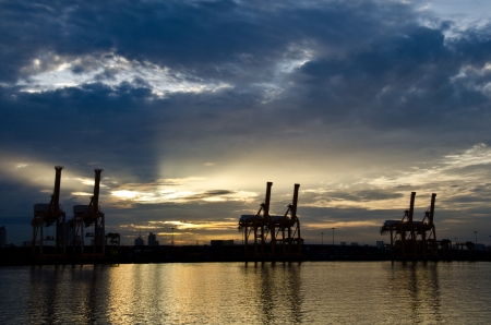 Container Cargo freight ship with working crane bridge in shipyard at sunrise  for Logistic Import Export backgroundの写真素材