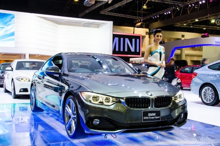 NONTHABURI - NOVEMBER 28   Bmw 420d Coupe M Sport car with unidentified model on display at The 30th Thailand International Motor Expo on November 28, 2013 in Nonthaburi, Thailand のeditorial素材