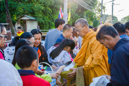 LOPBURI, THAILAND - JANUARY 1: Thai people give food offerings to a Buddhist monk on 1 January, 2015 in Lopburi, Thailand. Buddhist Thai traditional, people will make merit making by give food to monk.のeditorial素材