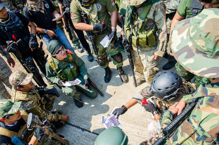 SUPANBURI - FEBRUARY 7 : Airsoft team member in during action await commands befor start mission to...