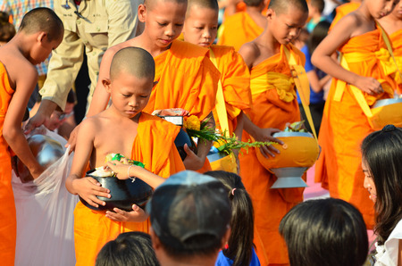 LOPBURI - APRIL 9: People give food offerings to a Buddhist monk on April 9, 2016 in Lopburi,...