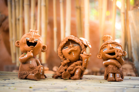 Clay dolls on bamboo table.の写真素材