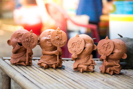 Clay dolls on bamboo table.の写真素材