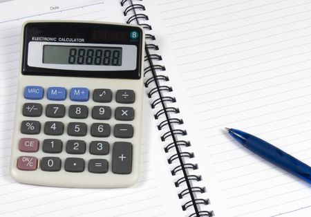 Note book with a pen and calculatorの写真素材