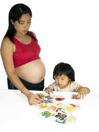 Pregnant woman teaching daughter study with white background.の写真素材