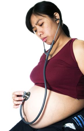 A pregnant women listen her tummy with stethoscopeの写真素材