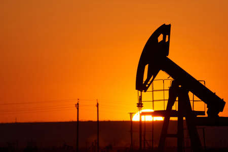 Oil pump oil rig energy industrial machine for petroleum in the sunset background for design. A oil...