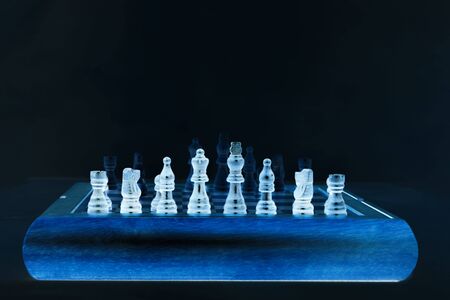 Chess on a chessboard. Black background.の写真素材