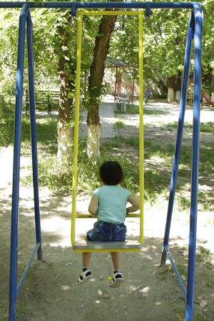 Little girl riding on a swing.の写真素材