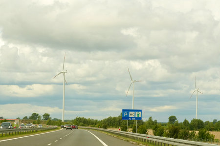 View on the road in Belgium to Gelderland with wind turbines.