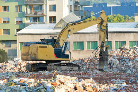 Demolition of a building with a yellow excavator in the city