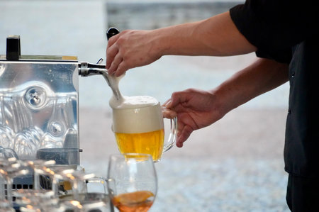 Barman pouring beer into a glass from the machine, close-up