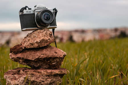 Morocco, Casablanca - January 30, 2021: An old film camera PENTAX K1000 is displayed inside a green grass in nature.のeditorial素材
