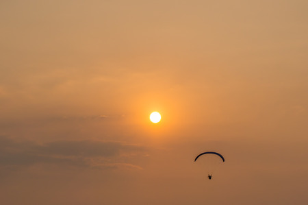 silhouette of paramotor with sunset skyの写真素材