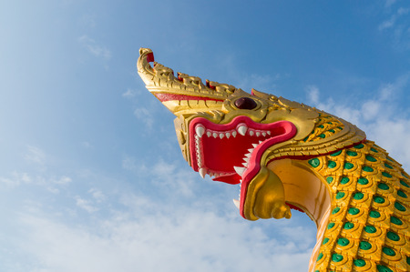 serpent king or king of naga statue in thai temple on blue sky backgroundの写真素材