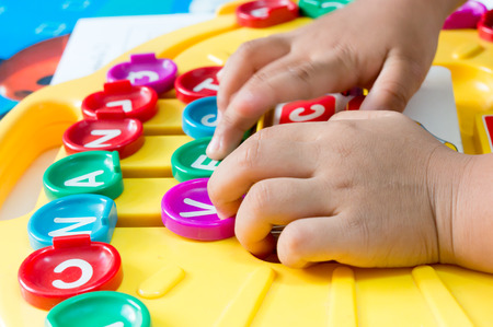 Children's Hand  to play alphabet games, Selective focus to Alphabetの写真素材