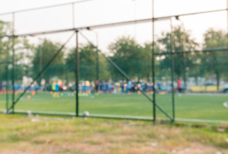 Blur of young kids playing a youth soccer match outdoors on an green soccer pitch.の写真素材