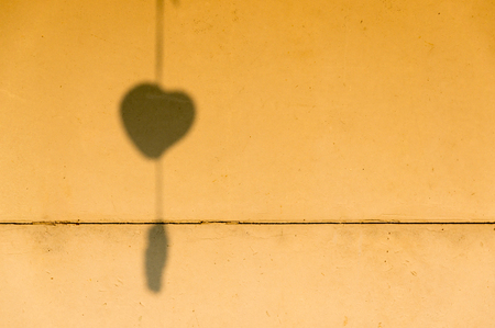 Heart-shaped shadow on the old wallの写真素材