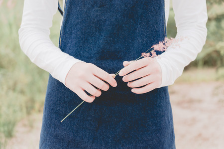The hand of the young girl with flower in nature backgroundの写真素材