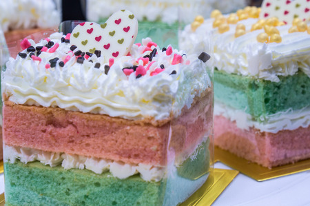 Rainbow cake with heart toppingの写真素材