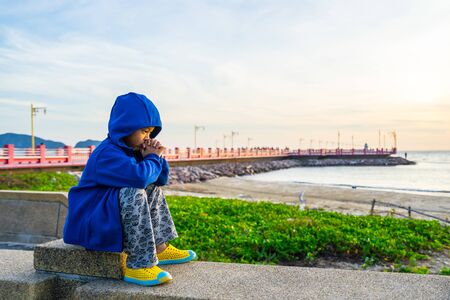 Prachuap Khiri Khan province, Thailand  - December 30, 2017 : Asian boy standing looking the beach at Saran Vi Tee Bridge ao prachuap, Prachuap Khiri Khan province, Thailand.のeditorial素材