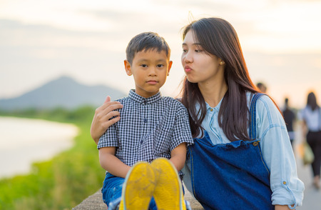 Boy and girl have  teasing each other , The Boy  displeased with a girl  in outdoor on sunsetの写真素材