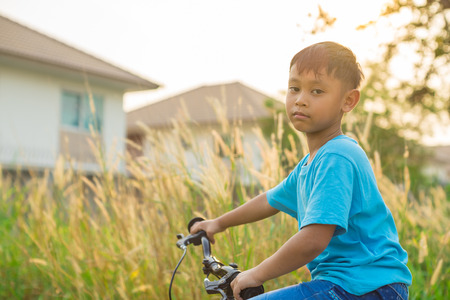 asian boy riding bicycle in public parkの写真素材