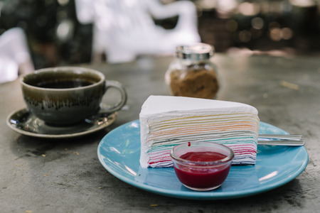 Rainbow crepe cake with strawberry jam on blue plate pastel colorの写真素材