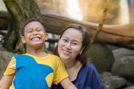 mom and boy travel at waterfall