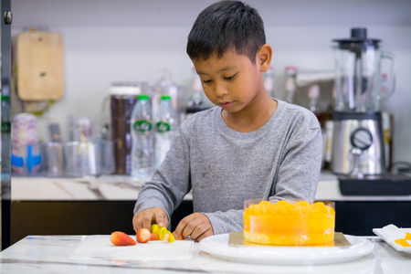 happy kid boy making a cakeの写真素材
