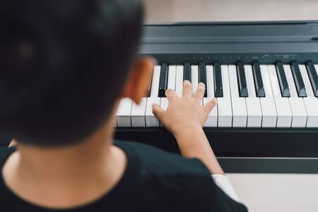 An asian boys  playing the piano.の写真素材