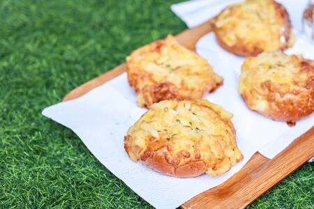 bread on wooden plate and green grass