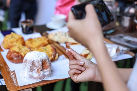 woman's hand is taking picture mini heart with bread on the tableの写真素材