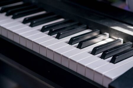 closeup side view of piano keyboard with low lightの写真素材