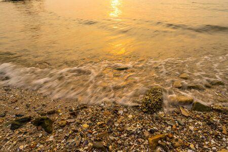 Waves washed into the shore in sunset with  slow shutter speed