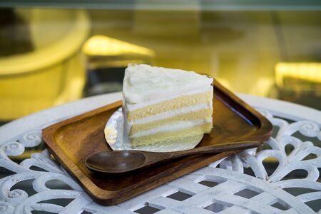Piece of Coconut Cake on wooden plate in shopの写真素材
