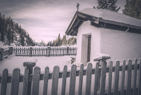 Vintage chapel in winter settings - Winter scenery with a small, rustic chapel covered with snow,...