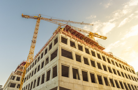 Building under construction and tower crane - Office building under construction and the two tower...