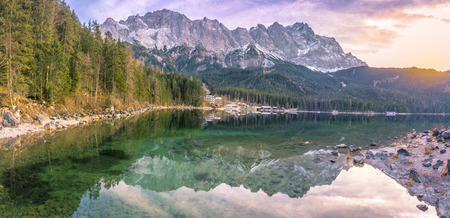 Alpine landscape with the German Alps mountains reflected in the Eibsee lake on a sunny day of...