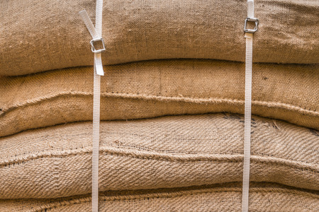 Close-up image of jute sacks filled with goods, piled upon each other and tied up, ready for transportation.の写真素材